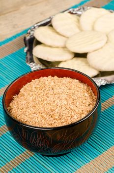 Bowl with fresh bran and some cookies in the background