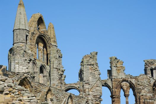 Close-up of the Whitby Abbey gothic ruins with the top of the facade and nave column during a sunny day. Whitby, North Yorkshire, England, United Kingdom, Europe