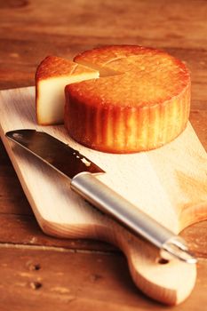 scissored cheese and knife on a wooden board