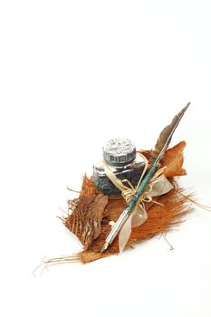 Vintage feather quill and inkwell over white background