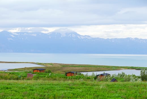 Iceland summer landscape. Fjord, house, mountains. Panorama.