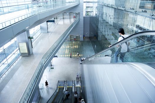 Singapore, Republic of Singapore - March 05, 2013 : People on escalators at Changi International Airport on  in Singapore. Changi Airport serves more than 100 airlines operating 6,100 weekly flights connecting Singapore to over 220 cities