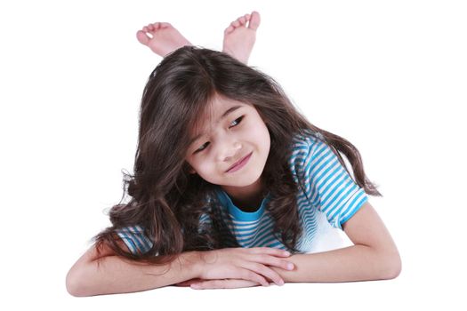 Seven year old biracial girl lying down on floor, smiling at camera