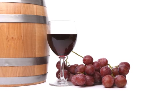 A glass of red wine with grapes and barrel on the white background.