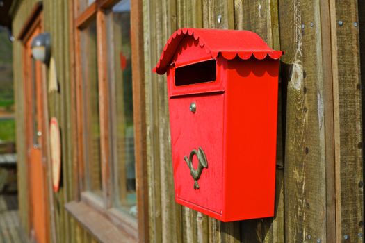 Old red Mailbox at wooden house in Iceland. Horizontal shot