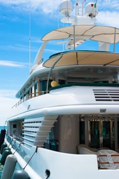 Luxury yacht with Italian flag docked in marina on a bright day