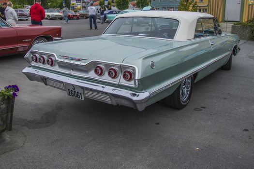 The image is shot at a fish-market in Halden, Norway where there every Wednesday during the summer months are held classic American car show.