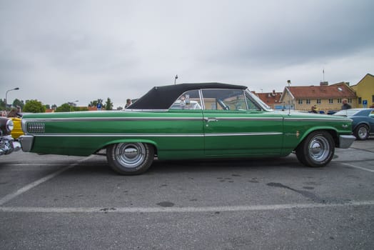 The image is shot at a fish-market in Halden, Norway where there every Wednesday during the summer months are held classic American car show.