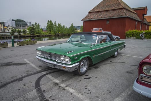 The image is shot at a fish-market in Halden, Norway where there every Wednesday during the summer months are held classic American car show.