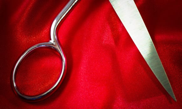 steel scissors on red fabric