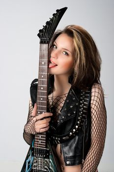 Woman with guitar in black lingerie posing in studio on light background