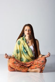 young indian woman posing sitting on the floor in studio