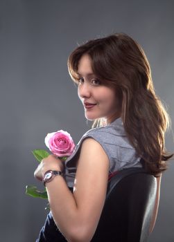 portrait of a beautiful young girl with a pink rose