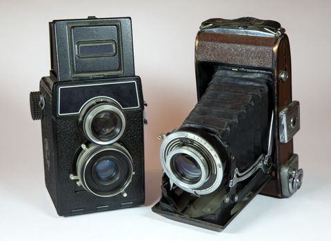 two vintage cameras on light background in studio