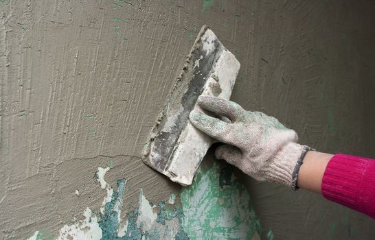 hand with a trowel plaster wall outdoor