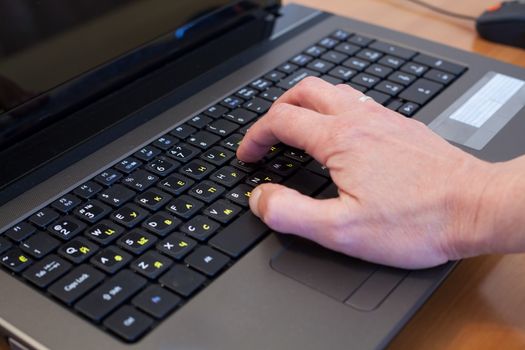 man's hand on a black computer keyboard