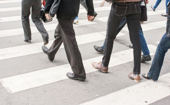 legs of pedestrians in a crosswalk on summer day