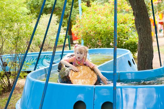 child in the boat in the amusement park