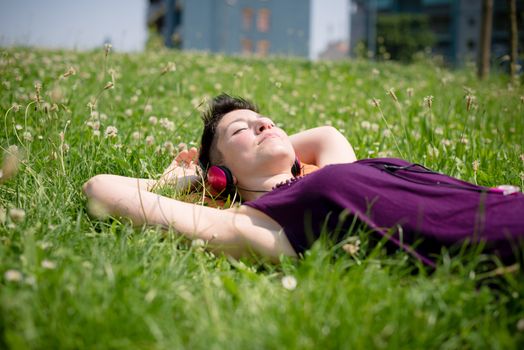 beautiful hipster short hair woman listening music in the park in the city