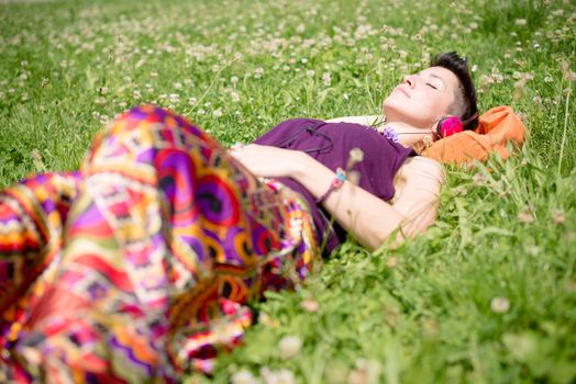 beautiful hipster short hair woman listening music in the park in the city