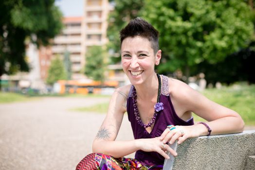 beautiful hipster short hair woman in the park in the city