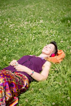 beautiful hipster short hair woman listening music in the park in the city