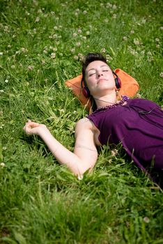 beautiful hipster short hair woman listening music in the park in the city