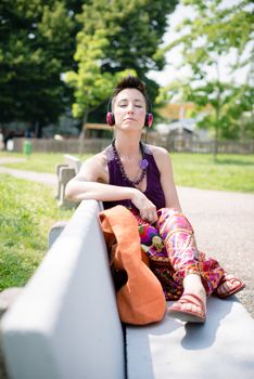 beautiful hipster short hair woman listening music in the park in the city