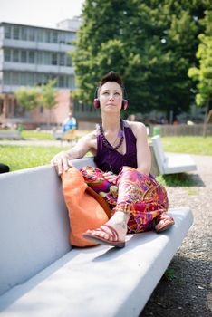 beautiful hipster short hair woman listening music in the park in the city