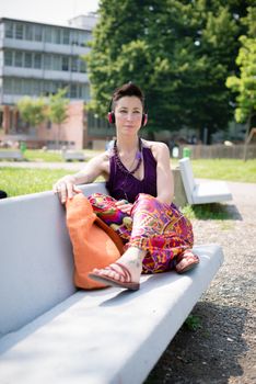 beautiful hipster short hair woman listening music in the park in the city