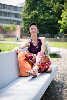 beautiful hipster short hair woman listening music in the park in the city