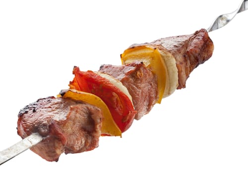 Hot roasted meat with onion, tomato and pepper on the metal skewer