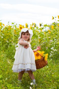 Little girl with a big wattled basket with sunflowers