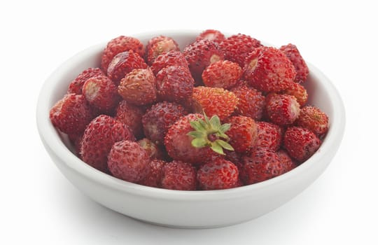 Handful of wild fresh strawberries on the white plate