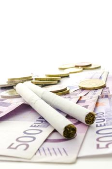 Cigarettes on Euro banknotes representing how expensive smoking habit is.