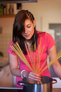 happy woman cooking spaghetti