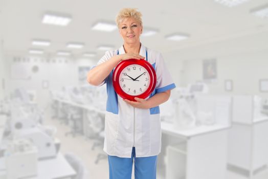 Mature doctor with clock at medical office