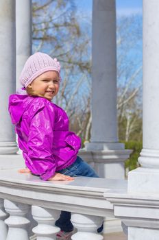 Little smiling girl on bench at park