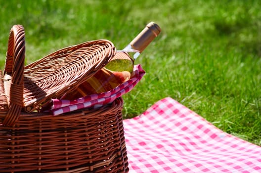 Picnic basket with wine bottle at lawn