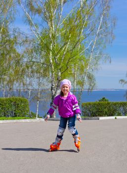 Little girl skating on roller skates at park