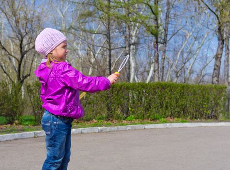 Little girl with soap bubbles at park