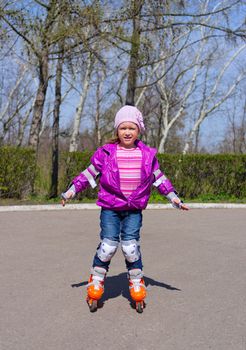 Little girl skating on roller skates at park