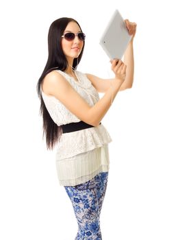 Girl in sunglasses and blue pants with tablet PC isolated
