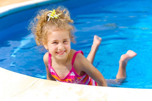 Pretty little girl in swimming pool outdoors