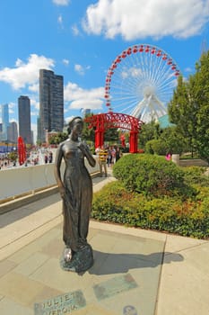 CHICAGO, ILLINOIS - SEPTEMBER 4: Statue, tourists and rides at the Navy Pier in Chicago, Illinois on September 4, 2011. The Pier is a popular destination with many attractions on Lake Michigan.