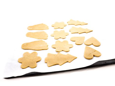 Gingerbread cookies, on white baking paper and black plate towards white background