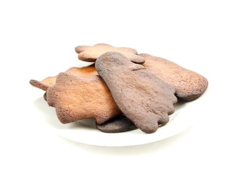 Burned gingerbread cookies on white plate towards white background
