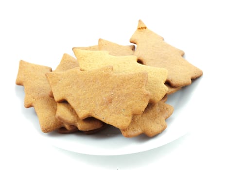 Gingerbread cookies, tree shape, on white plate towards white background