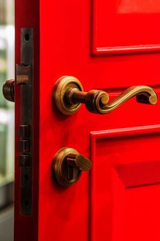 Red color wooden door with brass bolt