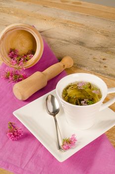 Homemade valerian infusion, with mortar and pestle in the background